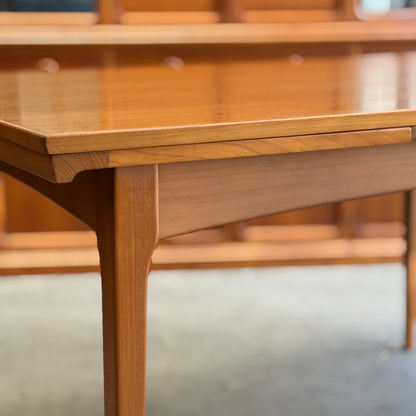 Close-up of the Fler 64 Rectangular Extension Table (Refine) featuring a smooth finish and tapered legs, highlighting vintage Australian design, with blurred wooden furniture in the indoor background.