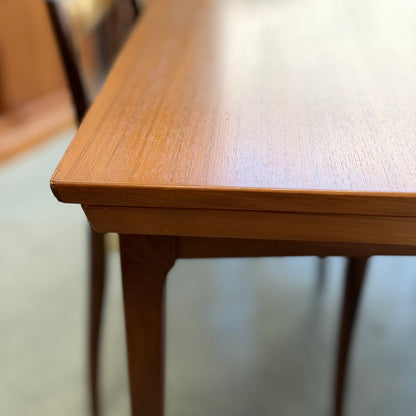 A close-up of the Fler 64 Rectangular Extension Table (Refine) shows its smooth, light brown finish. A slender-legged wooden chair appears in the background, highlighting the clean, polished surface and classic vintage Australian design.