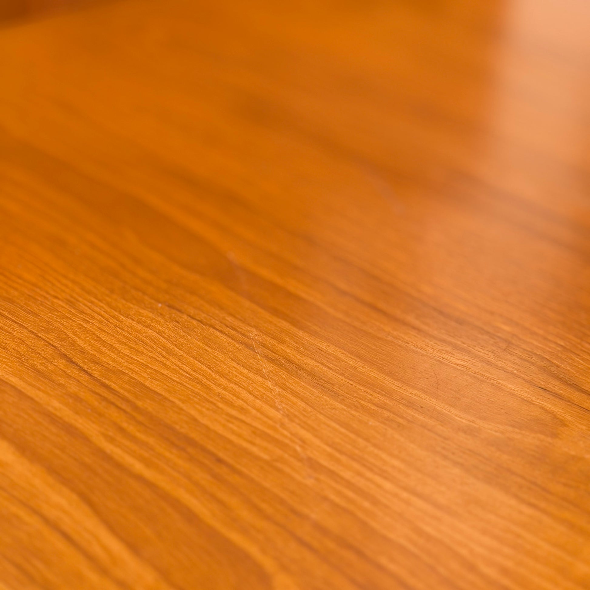 Close-up of the Mid Century Teak Danish Style Coffee Table – Circa 1970s (Revive), showing a smooth, polished teak surface with warm light brown tones and natural wood grain, reminiscent of vintage Scandinavian design.