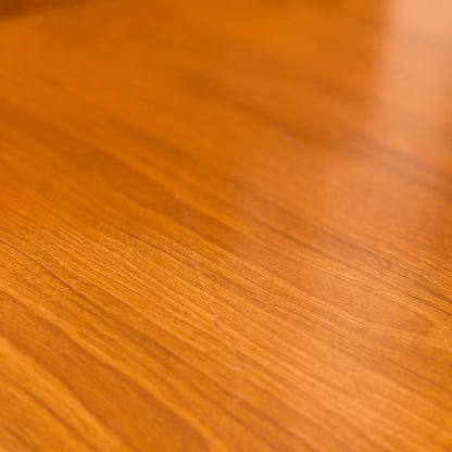 Close-up of the Mid Century Teak Danish Style Coffee Table – Circa 1970s (Revive), showing a smooth, polished teak surface with warm light brown tones and natural wood grain, reminiscent of vintage Scandinavian design.