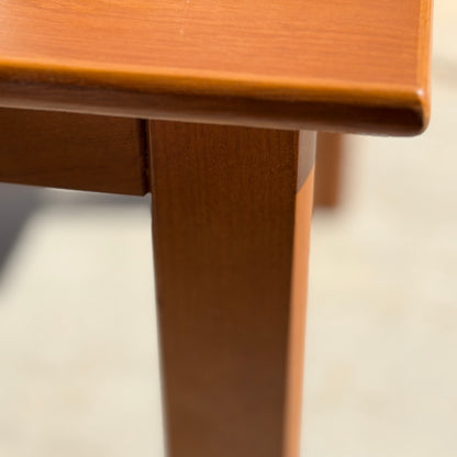 Close-up of a Mid Century Teak Danish Style Coffee Table – Circa 1970s (Revive), focusing on the smooth-finished corner, leg, and underside. The blurred background highlights its vintage Scandinavian design.