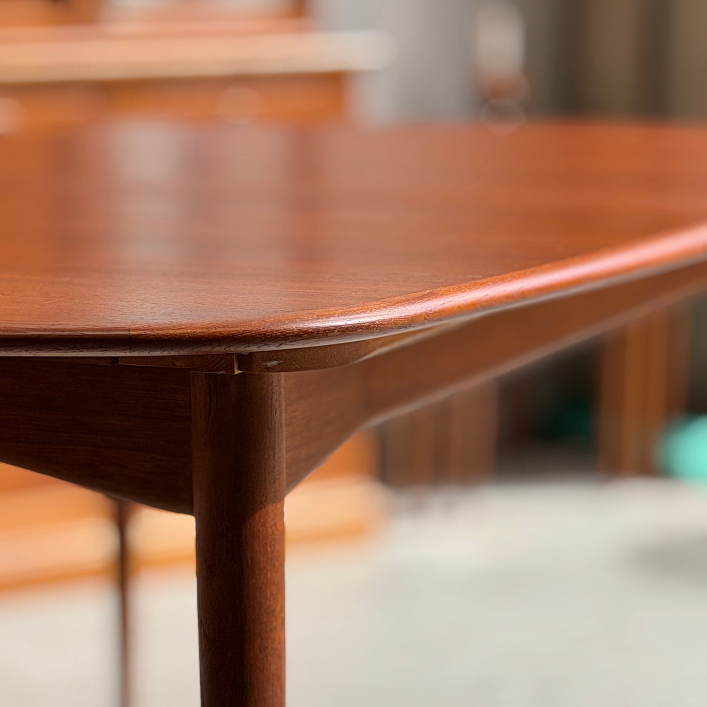 Close-up of the corner of a Fully Restored Parker No.92 D End Dining Table (Rediscover), highlighting its rounded edges, smooth finish, and mid-century modern craftsmanship in warm, natural light with a softly blurred background.