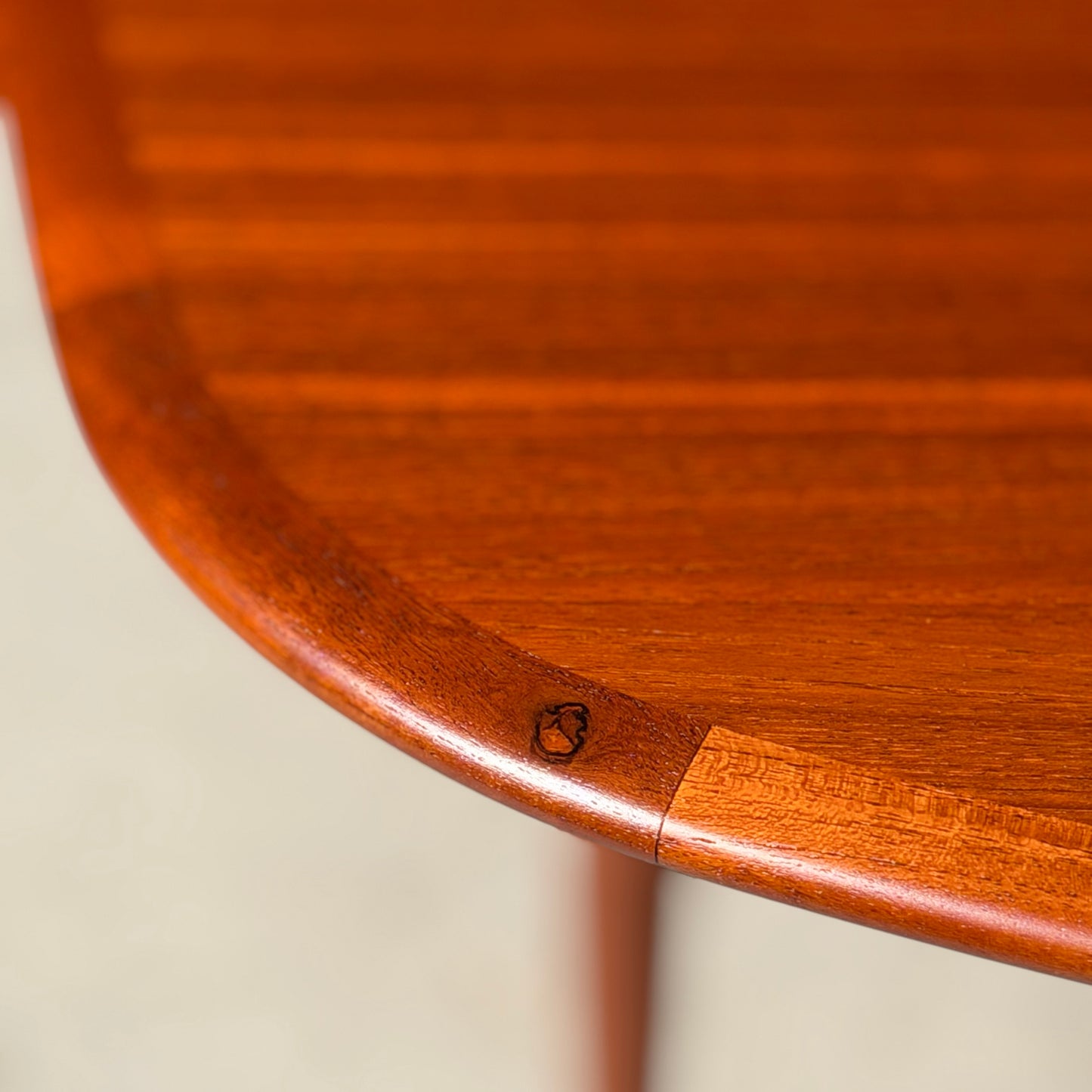 Close-up of the corner of a fully restored Parker No.92 D End Dining Table (Rediscover), highlighting its polished wood grain and distinctive mark on the rounded edge—a classic piece of vintage Australian furniture.