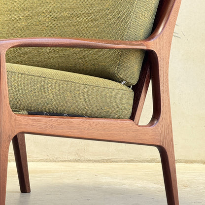 Close-up side view of the Don Rex Armchair - Green Forest (Rediscover), featuring mid-century Australian style with a wooden frame and green textured upholstery, set against a neutral background.