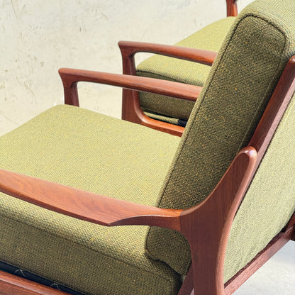 Close-up of the Don Rex Armchair - Green Forest (Rediscover), featuring Danish modernism with green textured upholstery and smooth, curved wooden arms and frame, set against a neutral background.