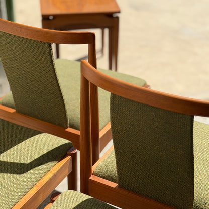 Four fully restored Parker T-Back Number 88 dining chairs in forest green (Rediscover) are displayed in sunlight, with a small wooden table behind them on a light floor, highlighting their classic mid-century modern charm.