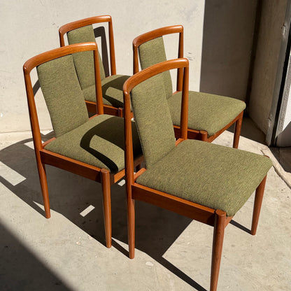 A set of four fully restored Parker T-Back Number 88 dining chairs in forest green (Rediscover) is arranged in a staggered formation on a sunlit concrete floor near a wall and open doorway.