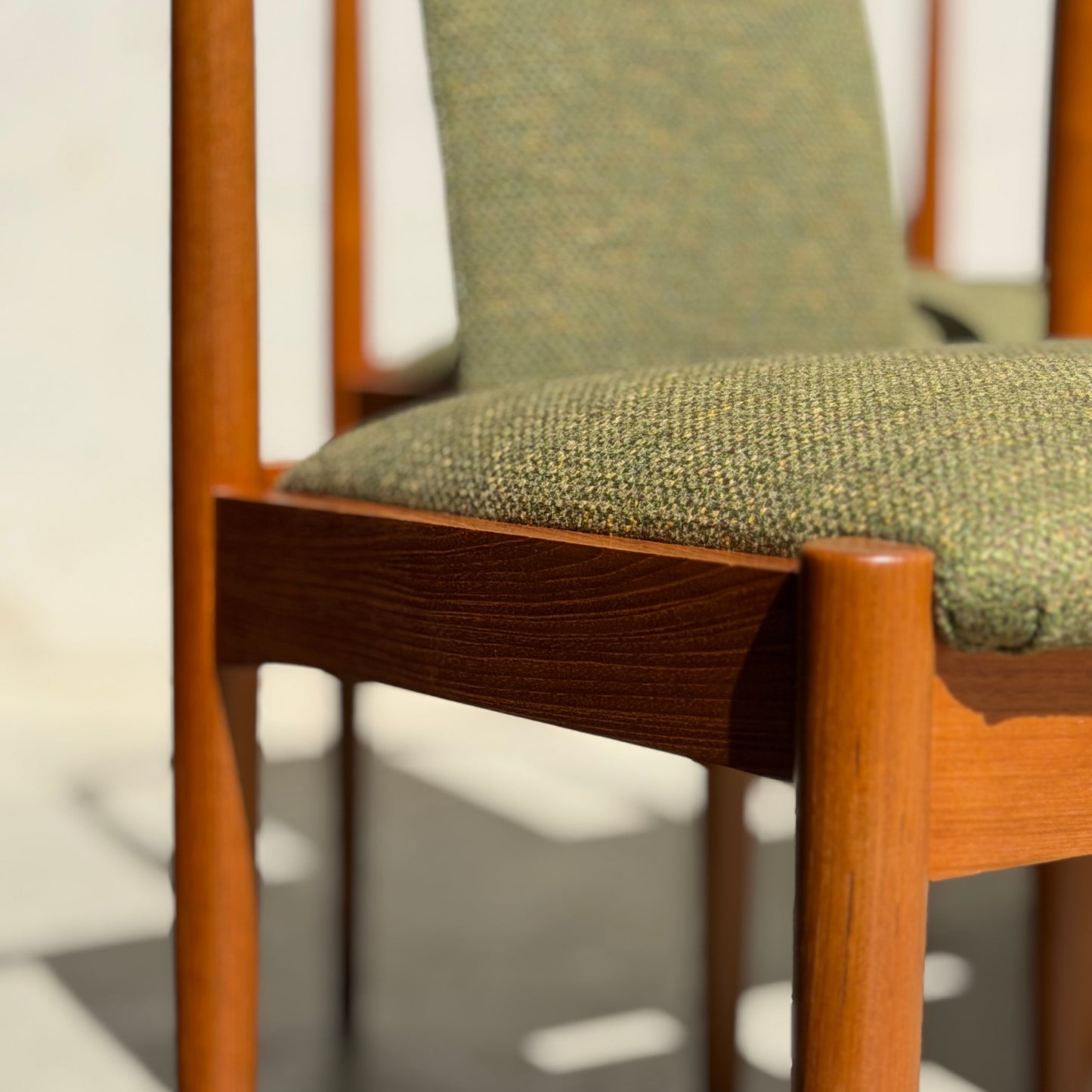 Close-up of a Fully Restored Parker T-Back Number 88 Dining Chair from the Set of 4 - Forest Green (Rediscover), featuring rounded legs and green textured fabric in natural light, exemplifying mid-century modern restored teak design.