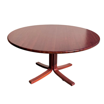 The Joe Rufenacht Designer Round Dining Table – Rare Mid-Century Gem in Solid Wood (Refine) features a central pedestal base with four flat feet, shown on a light concrete floor in natural sunlight.