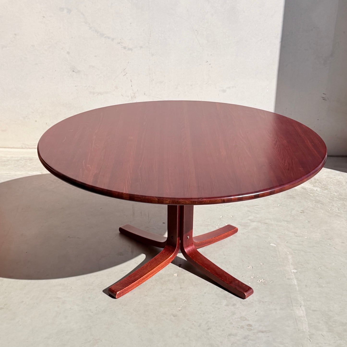 The Joe Rufenacht Designer Round Dining Table – Rare Mid-Century Gem in Solid Wood (Refine) features a single central pedestal and four curved legs, beautifully set on a light-colored floor with sunlight casting a soft shadow.
