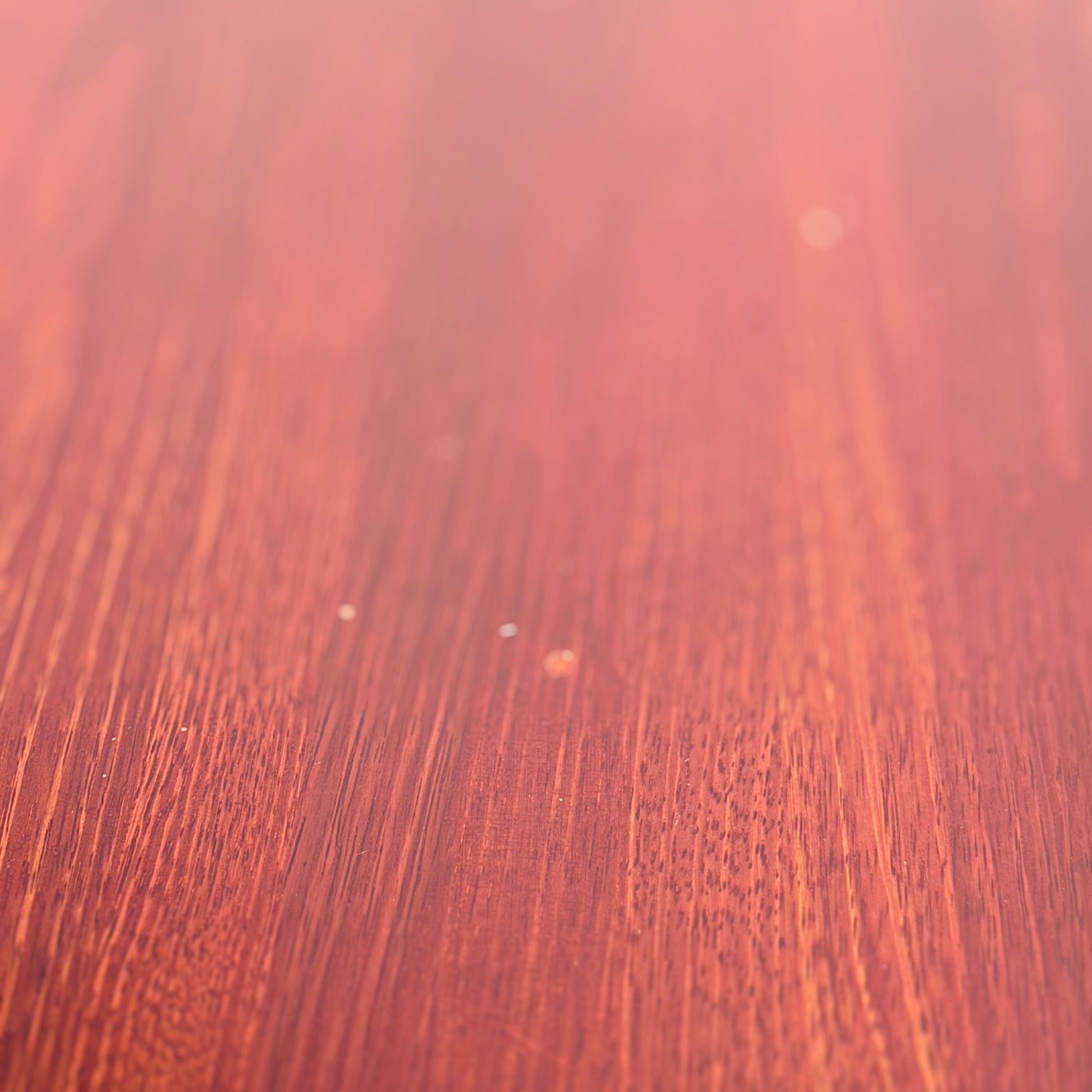 Close-up of the smooth, reddish-brown solid wood surface of the Joe Rufenacht Designer Round Dining Table—a rare mid-century gem—showcasing elegant grain and subtle texture that evoke refined craftsmanship.