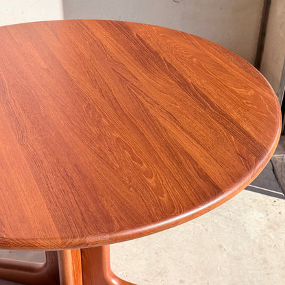 Fully restored solid teak Danish dining table (Rediscover) with a polished finish and visible wood grain, shown in sunlight on a light floor near a wall—a perfect choice for fans of vintage modern design.