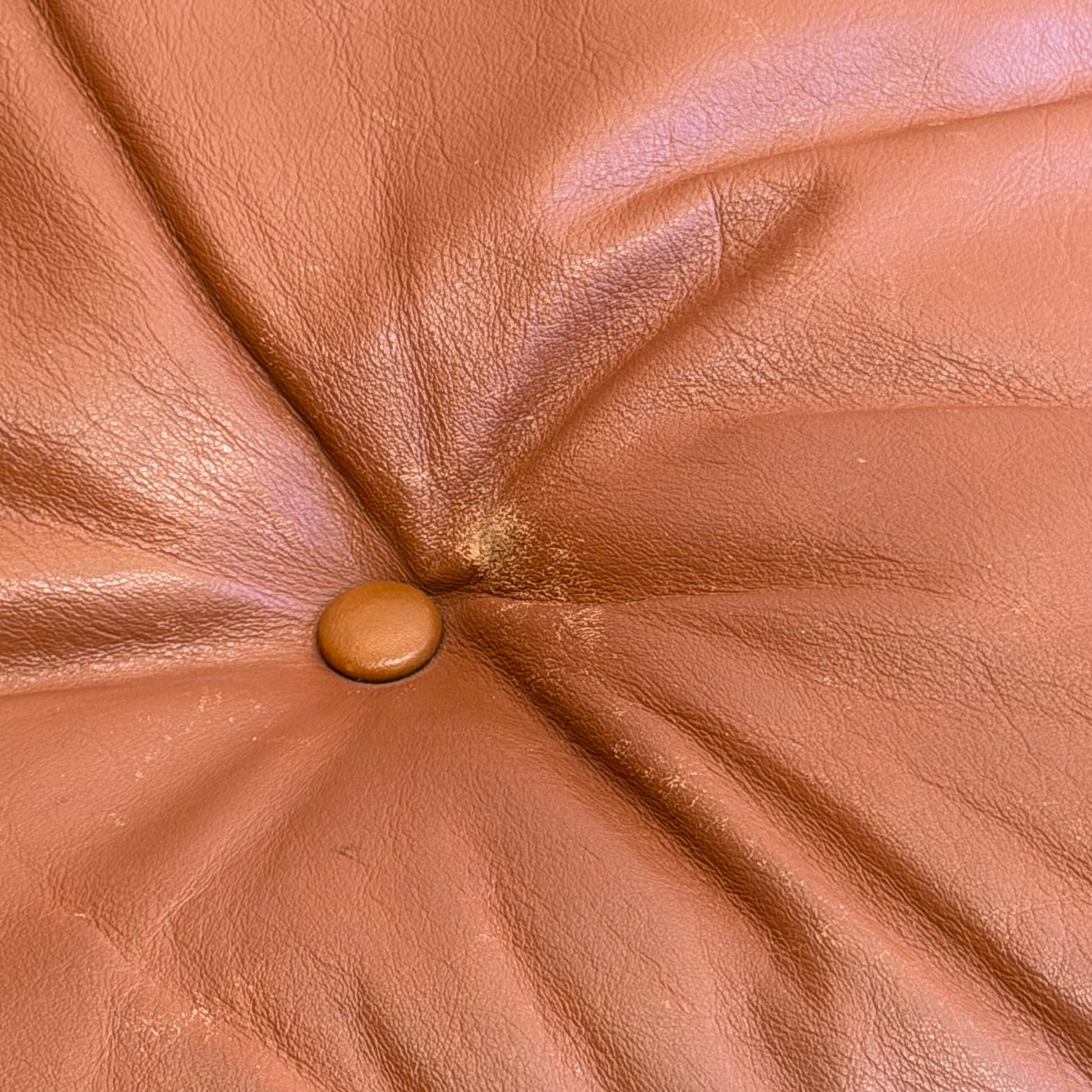 Close-up of brown leather upholstery with button detail, showing wear and texture—reflecting the classic design of the Signature Vintage Ingmar Relling Siesta Set: two lounge chairs and rare coffee table.