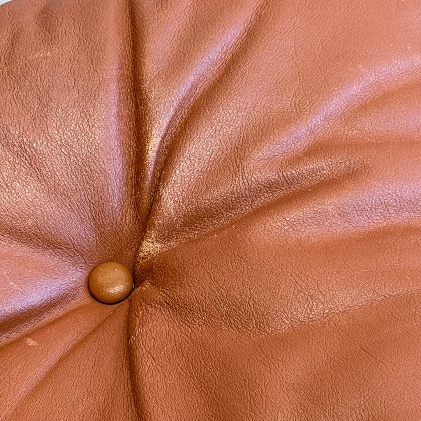 Close-up of a brown leather cushion with tufted stitching and central button, showcasing the Signature Vintage Ingmar Relling Siesta Set – Two Lounge Chairs & Rare Coffee Table’s classic Scandinavian mid-century style.
