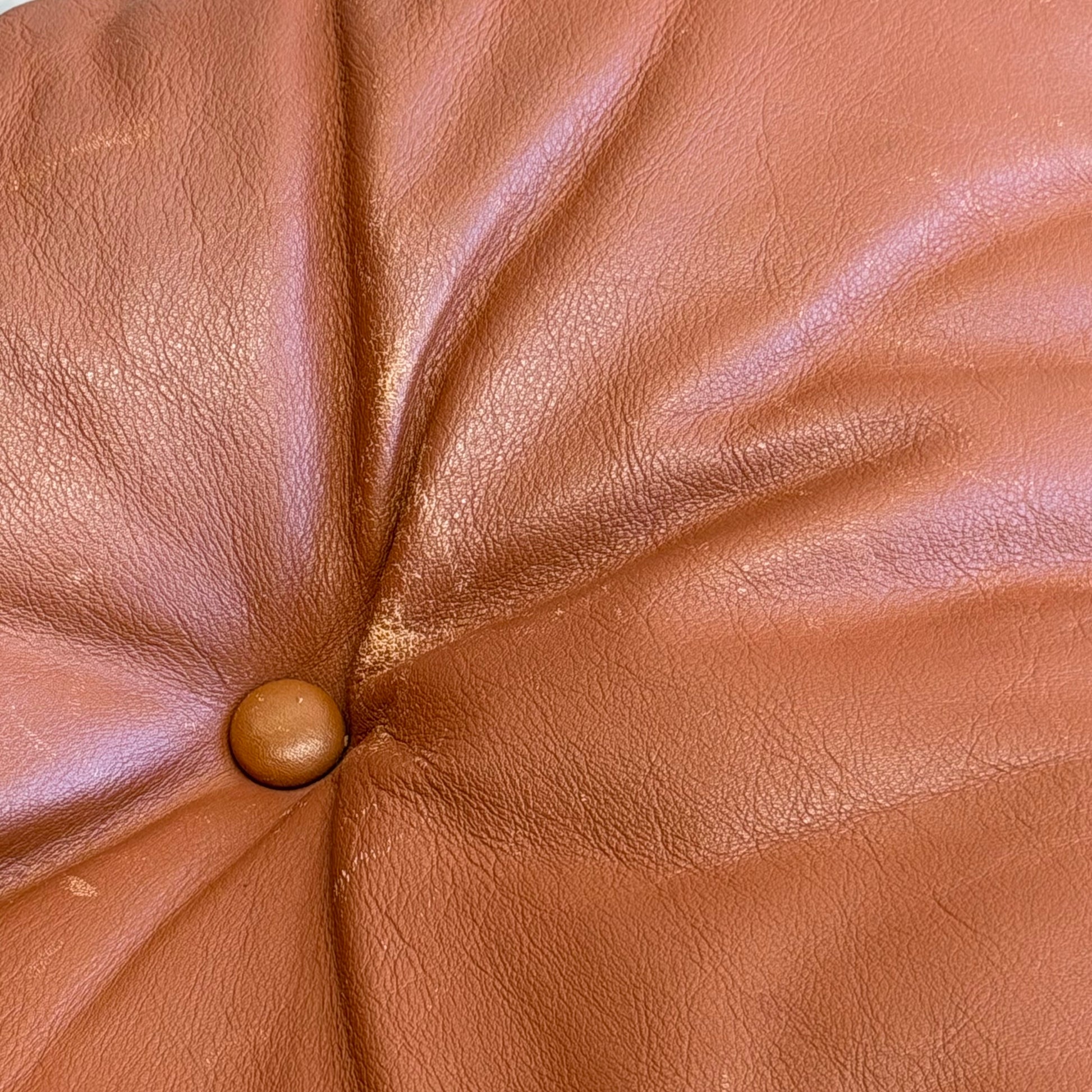 Close-up of a brown leather cushion with tufted stitching and central button, showcasing the Signature Vintage Ingmar Relling Siesta Set – Two Lounge Chairs & Rare Coffee Table’s classic Scandinavian mid-century style.