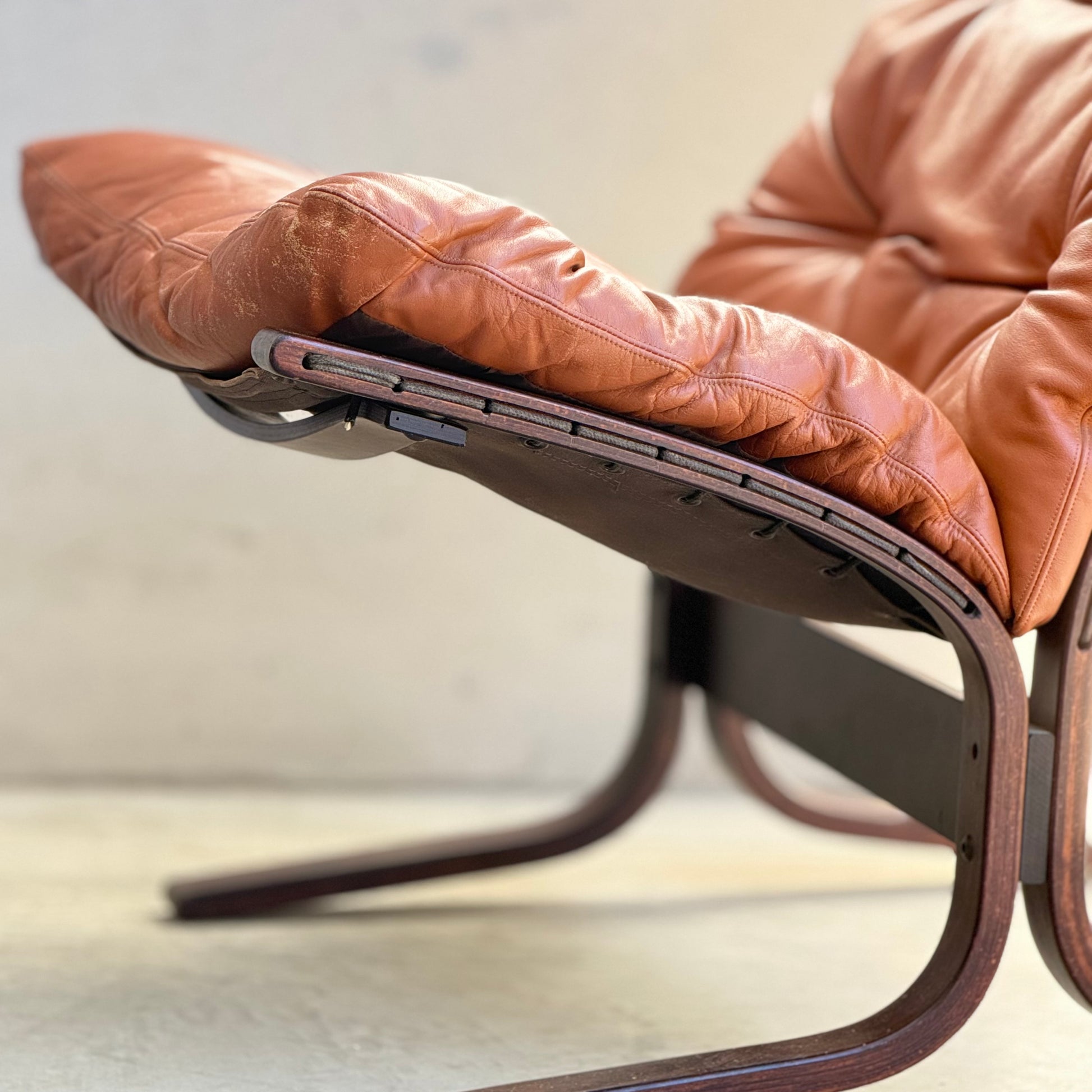 Side view of the Signature Vintage Ingmar Relling Siesta Set—two lounge chairs with curved dark wood frames and tufted brown leather seats, plus a rare coffee table—exemplifying classic Scandinavian mid-century design.