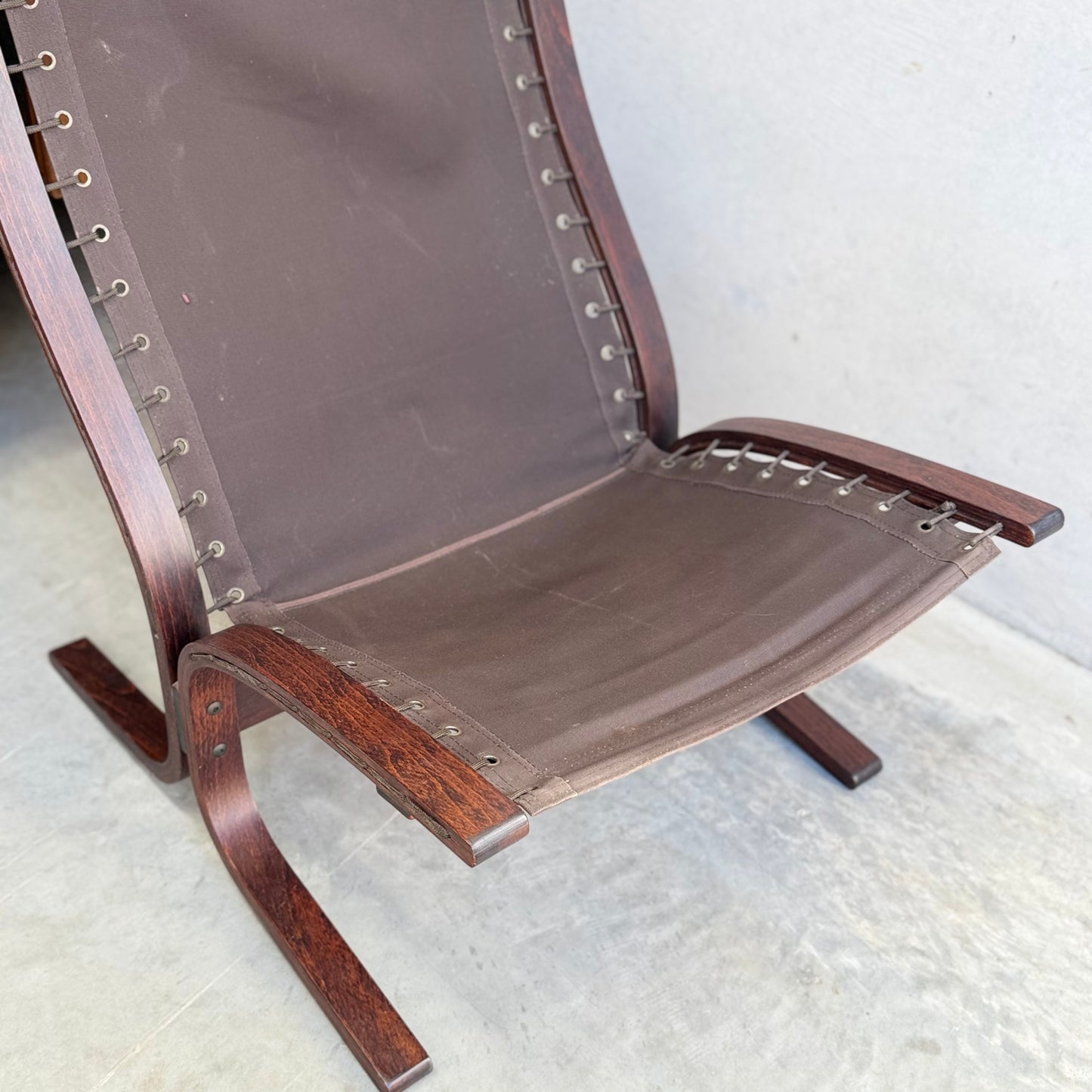 A close-up of the Signature Vintage Ingmar Relling Siesta Set—two lounge chairs with curved wood frames and canvas seats, plus a rare coffee table—shown on a light floor; a Scandinavian mid-century modern icon.