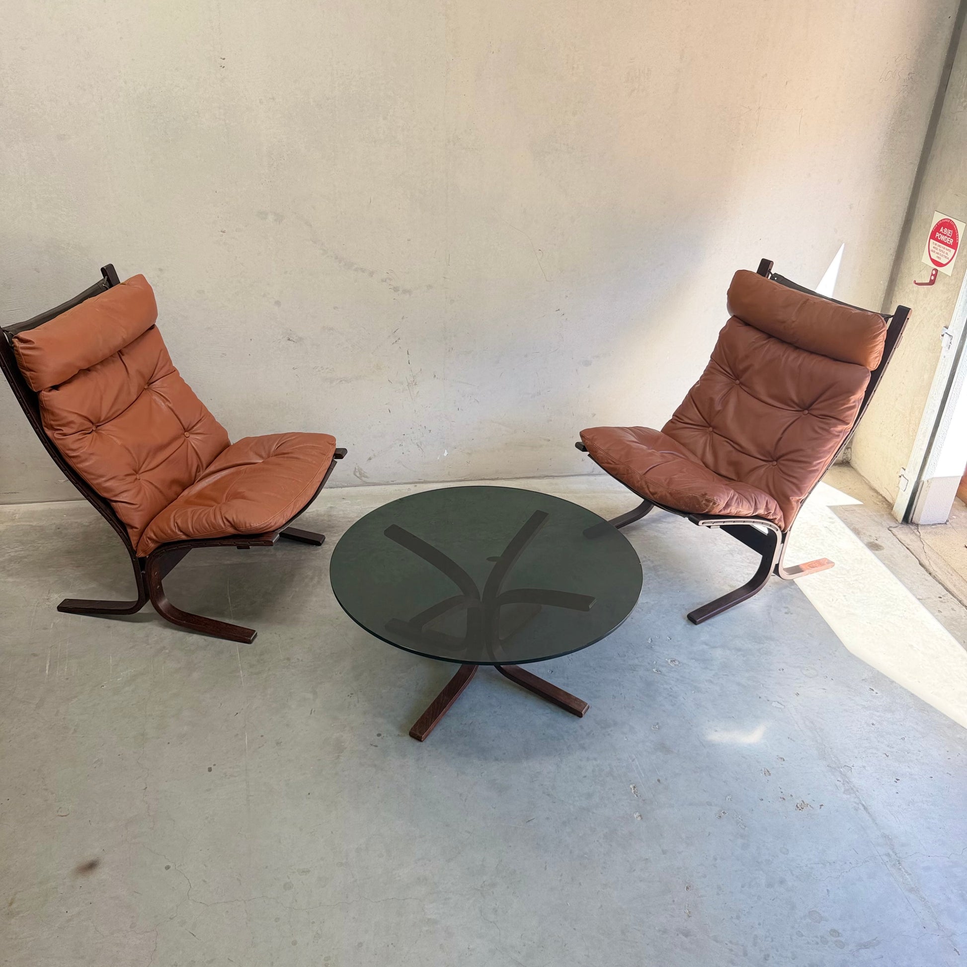 The Signature Vintage Ingmar Relling Siesta Set features two lounge chairs and a rare coffee table, arranged facing each other against a beige wall on a light gray floor.