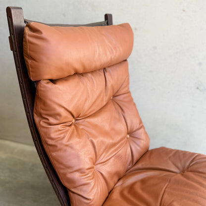 Close-up of the Signature Vintage Ingmar Relling Siesta Set – featuring two lounge chairs with high, dark wood frames and tufted tan leather, plus a rare coffee table. This Scandinavian mid-century set stands out against a light background.