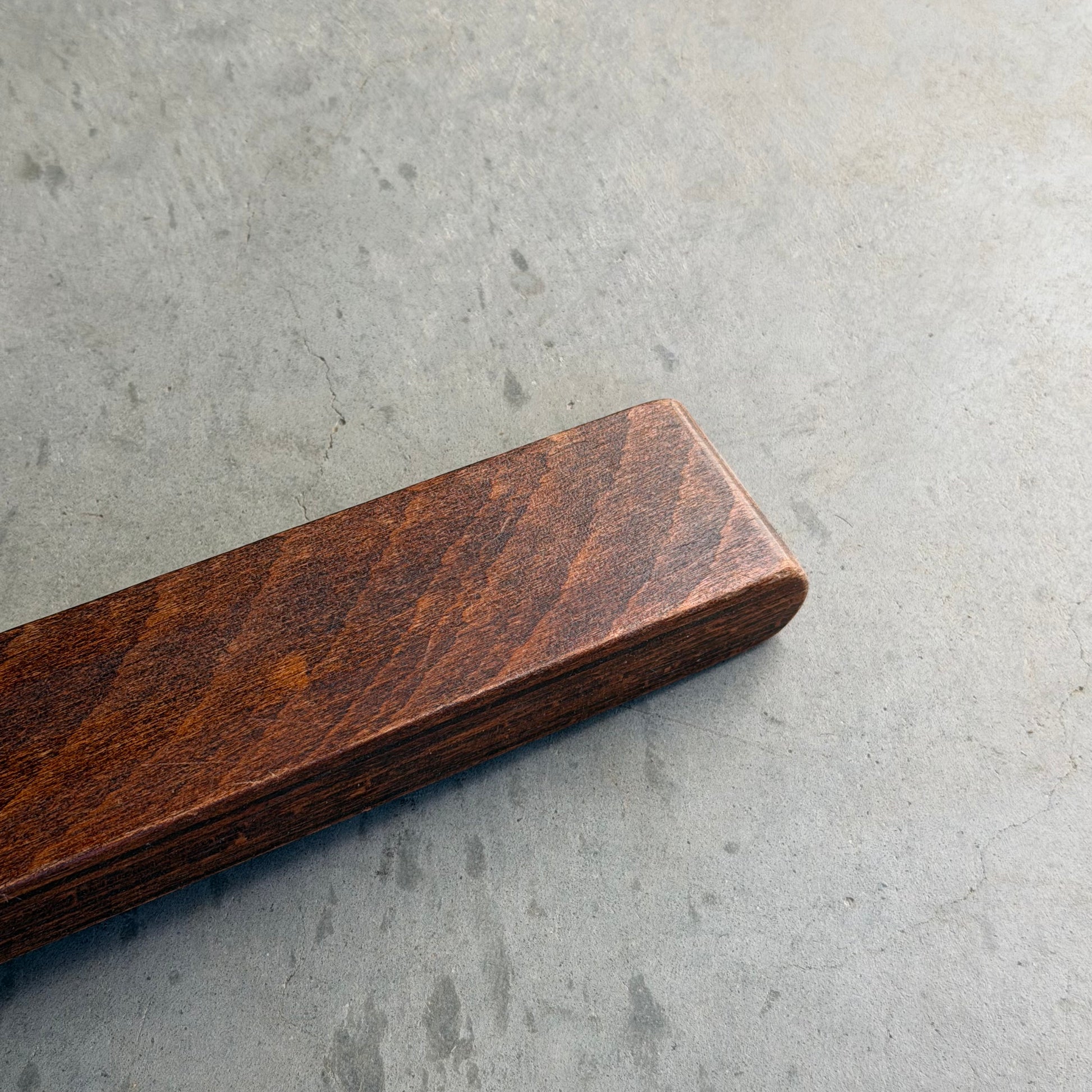 A close-up of the Signature Vintage Ingmar Relling Siesta Set’s rare coffee table, featuring rich dark wood and Scandinavian mid-century design, resting on a smooth gray concrete surface.