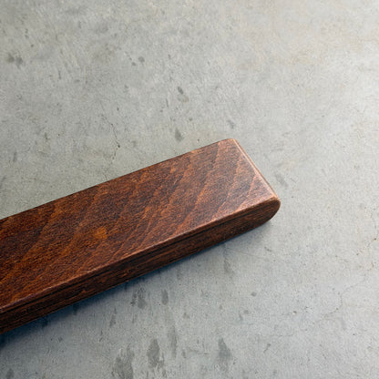 A close-up of the Signature Vintage Ingmar Relling Siesta Set’s rare coffee table, featuring rich dark wood and Scandinavian mid-century design, resting on a smooth gray concrete surface.