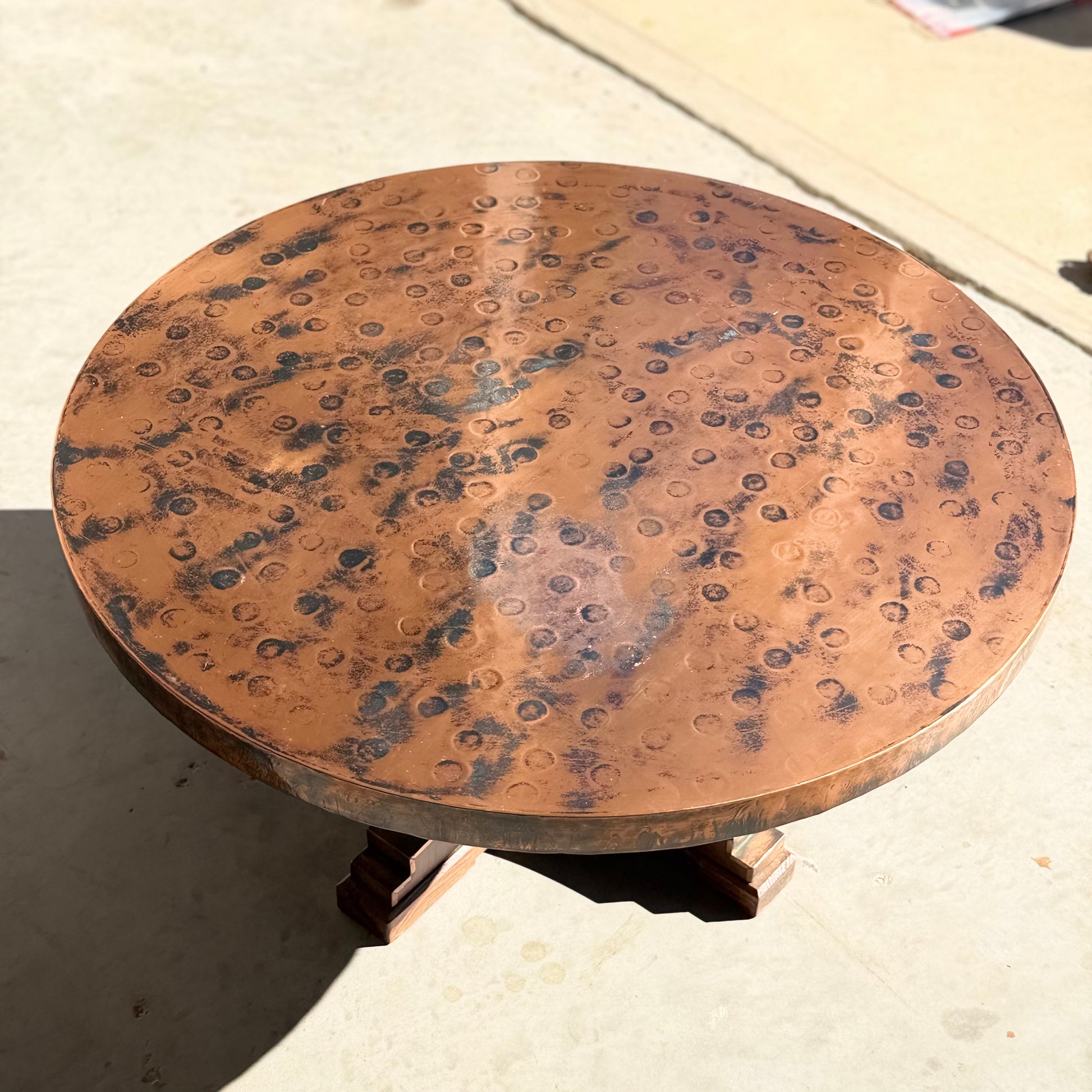 The Vintage Louis Berczi Hammered Copper Round Coffee Table – Rare Australian Collectible (Revive) features a hand-hammered, mottled copper top with circular patterns on a three-legged wooden base for an elegant vintage look.