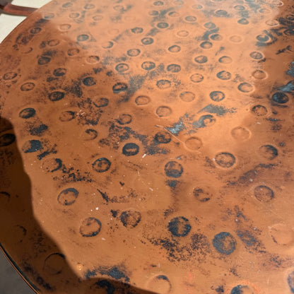 A close-up of the Vintage Louis Berczi Hammered Copper Round Coffee Table, a rare Australian collectible from Revive, featuring hand-hammered circular indentations, dark spots, and aged patina—ideal for vintage decor.