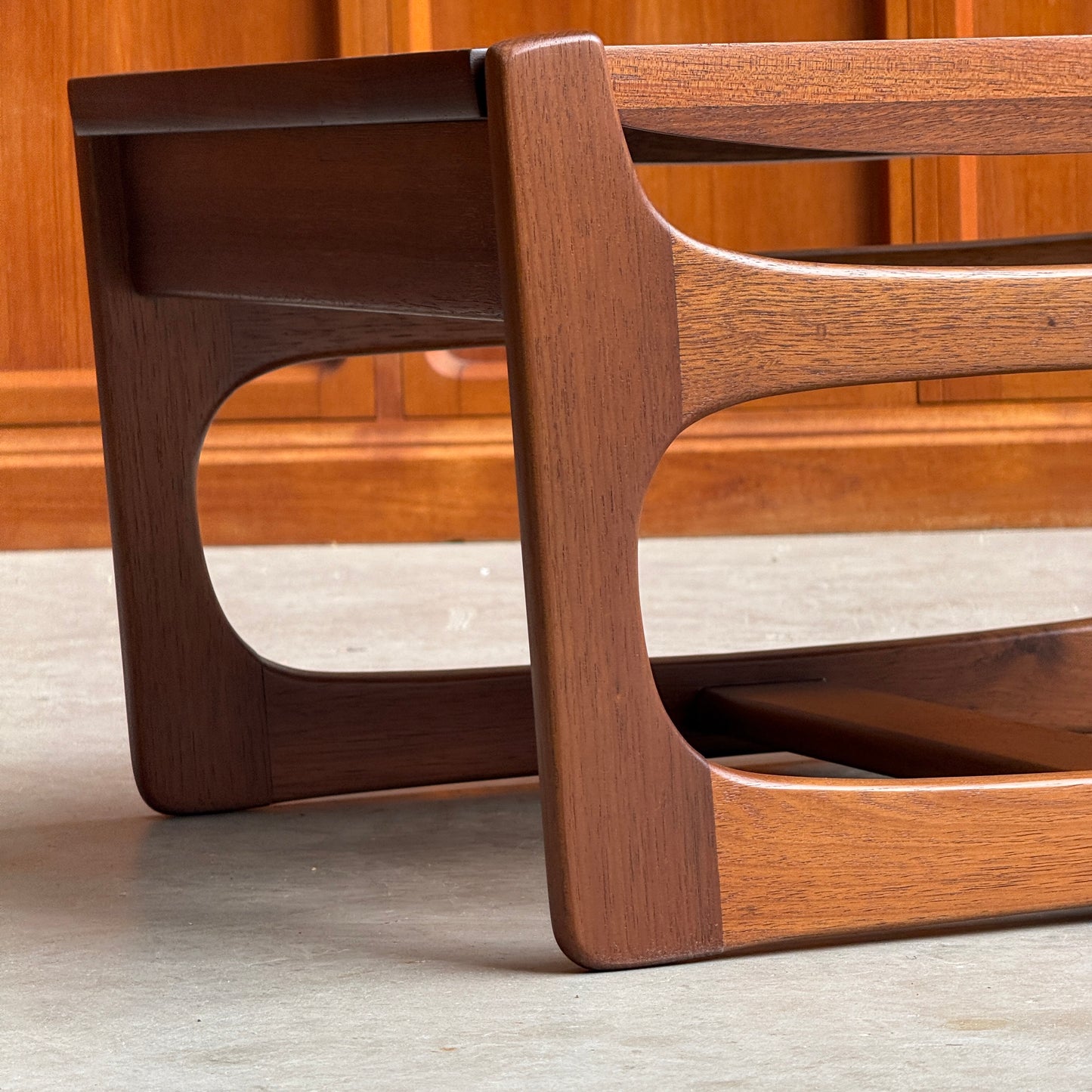 The Ultra Rare Gerald Easden Coffee Table in Blackwood features a sleigh leg base and mid-century modern design, showcased on a light gray floor before wood paneling. Its warm, polished tones evoke classic Australian vintage style.
