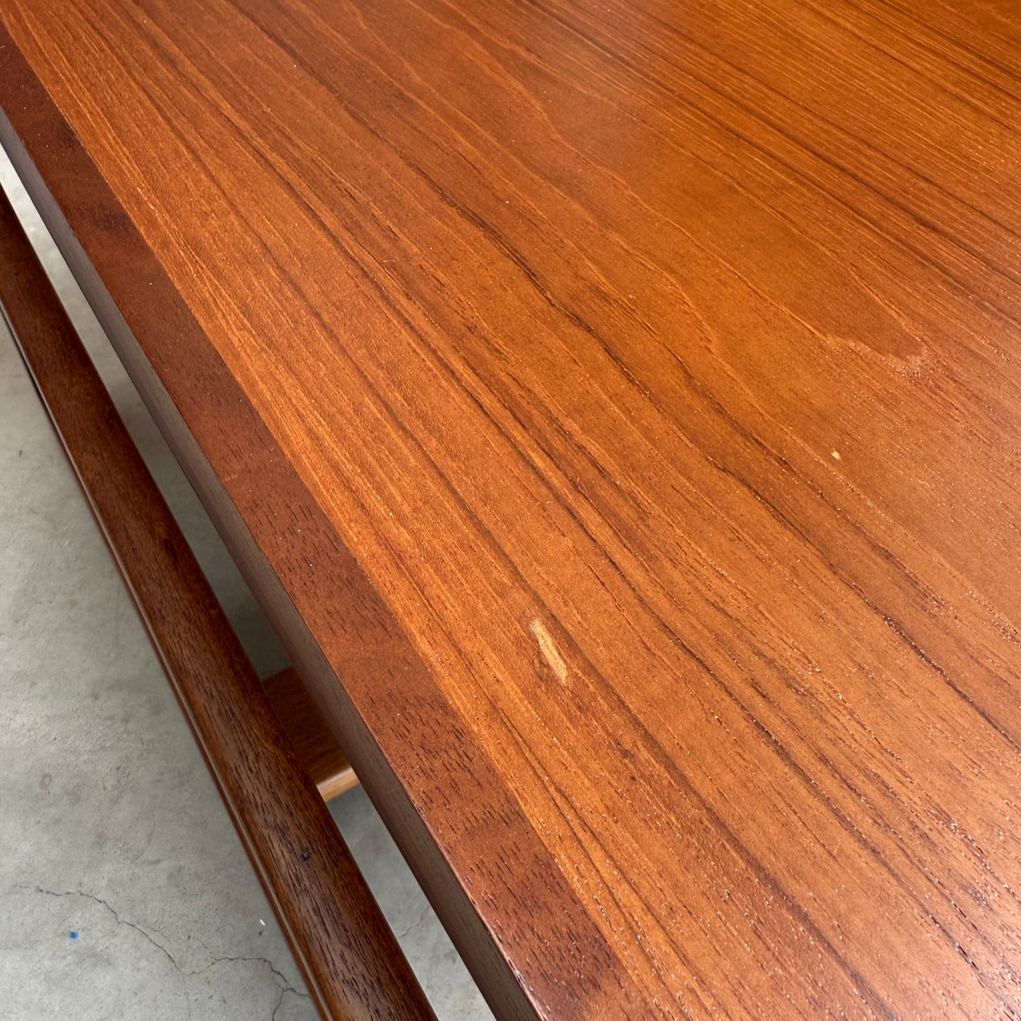 A close-up of the Ultra Rare Gerald Easden Coffee Table in Blackwood shows its sleigh leg base, rich brown finish, visible wood grain, and a small central scratch—distinctive features of this Australian vintage piece. Edge and leg details are also visible.