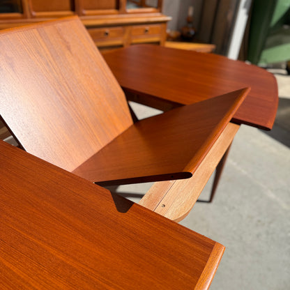 Fully restored Parker No.92 D End Dining Table (Rediscover) with extending leaves and a rich finish, sunlit on a gray floor, paired with vintage Australian furniture in the background.