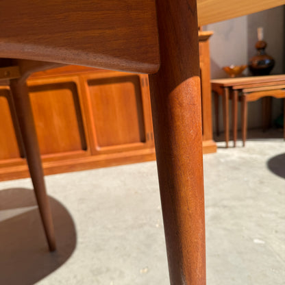 Close-up of a Fully Restored Parker No.92 D End Dining Table leg with warm sunlight casting shadows on concrete, while vintage Australian mid-century modern cabinets and nesting tables add timeless charm in the background.