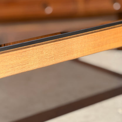 Close-up of the restored Tessa TC 21 Coffee Table Frame - (Revive) with a metal edge, highlighted in warm sunlight and a blurred backdrop—showcasing its modern minimalist design.