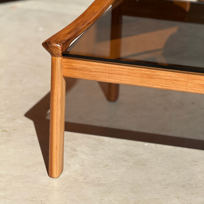 Close-up of the Tessa TC 21 Coffee Table Frame Restored - (Revive), featuring a glass tabletop and warm wood finish. The modern minimalist design and expert joinery craftsmanship are highlighted on a light-colored floor.