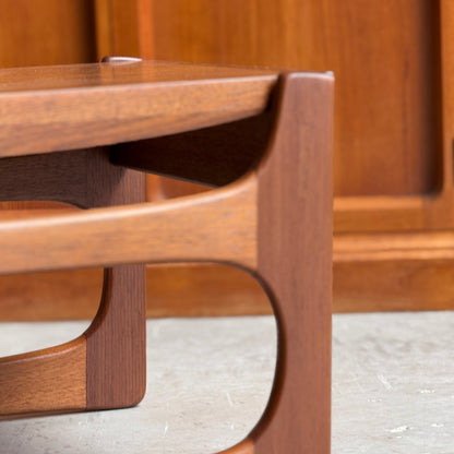 Close-up of the ultra rare Gerald Easden Coffee Table in Blackwood with a sleigh leg base, highlighting its elegant curved lines and mid-century modern design. The background shows matching wood paneling and a concrete floor.