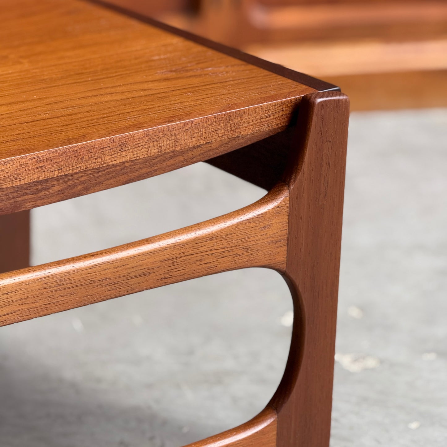 Close-up of the Ultra Rare Gerald Easden Coffee Table in Blackwood with sleigh leg base (Rediscover), featuring a smooth finish and curved mid-century modern design, inspired by Australian vintage furniture on a gray concrete floor.