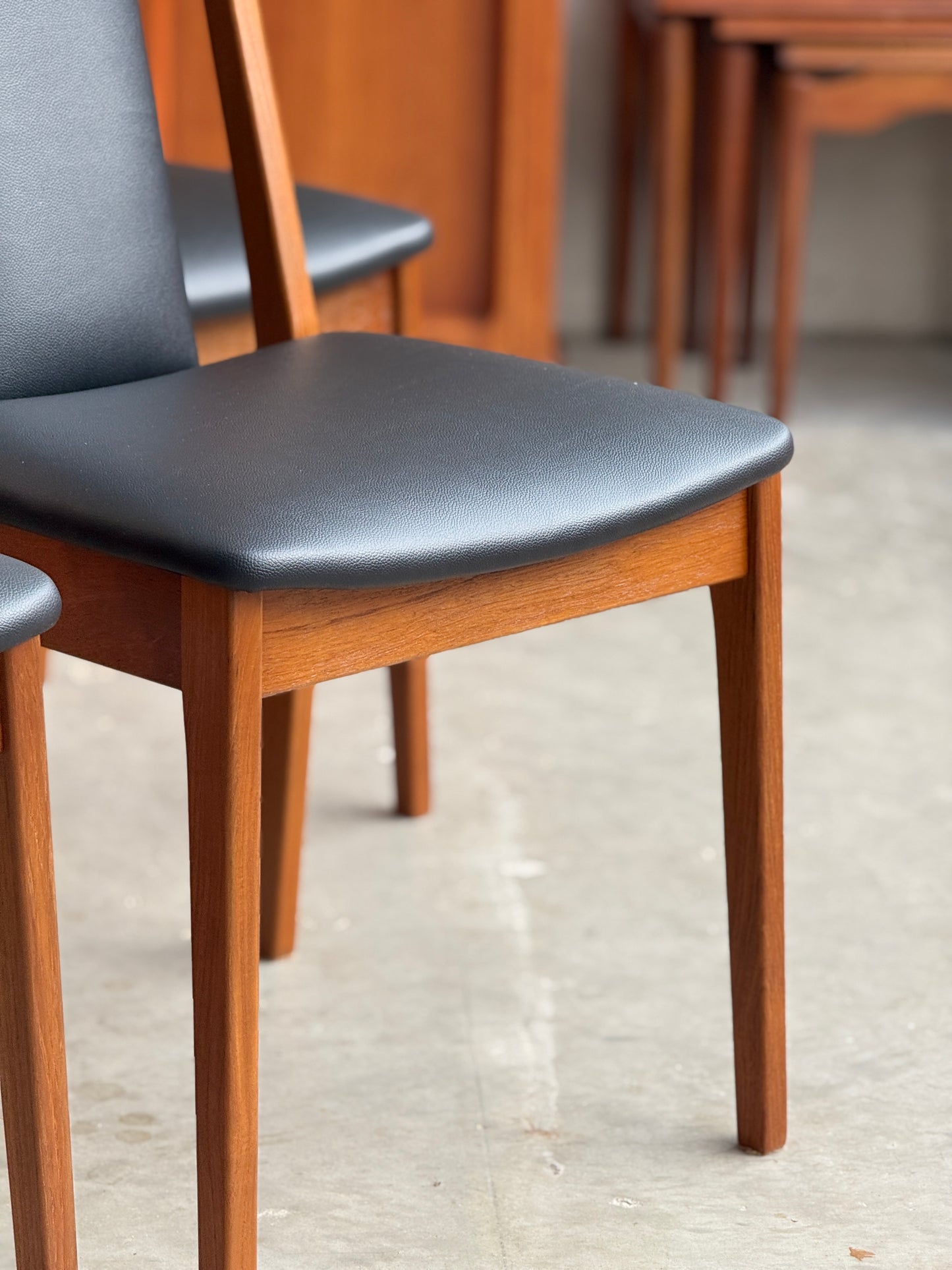 Front close up of Restored Noblett Boston T-back mid-century modern dining chairs showing open ladder back design and teak legs