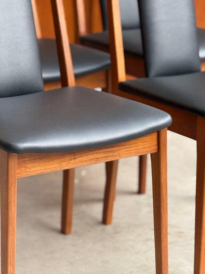 Close-up of a chair with wooden frame and black seat on a neutral background