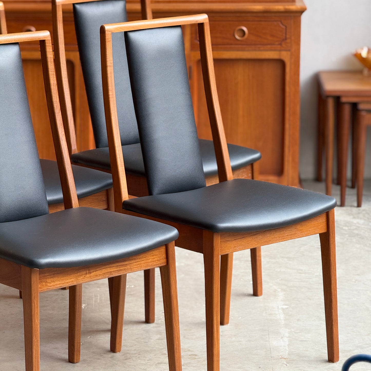 Close-up of restored Noblett T-back dining chair highlighting the signature open back and teak timber