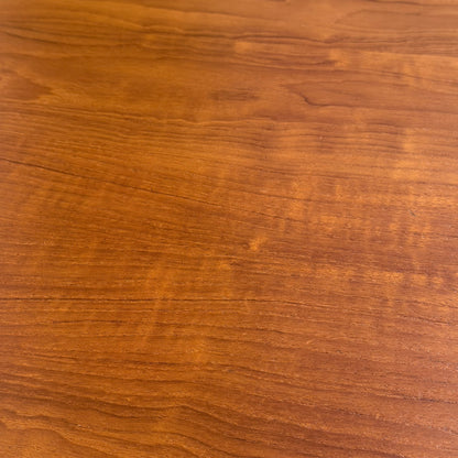 A close-up of the Fully Restored Parker No.91 Fixed Top Oval Table (Rediscover), featuring a smooth finish, distinctive natural grain, and warm brown tones evocative of classic mid-century design.