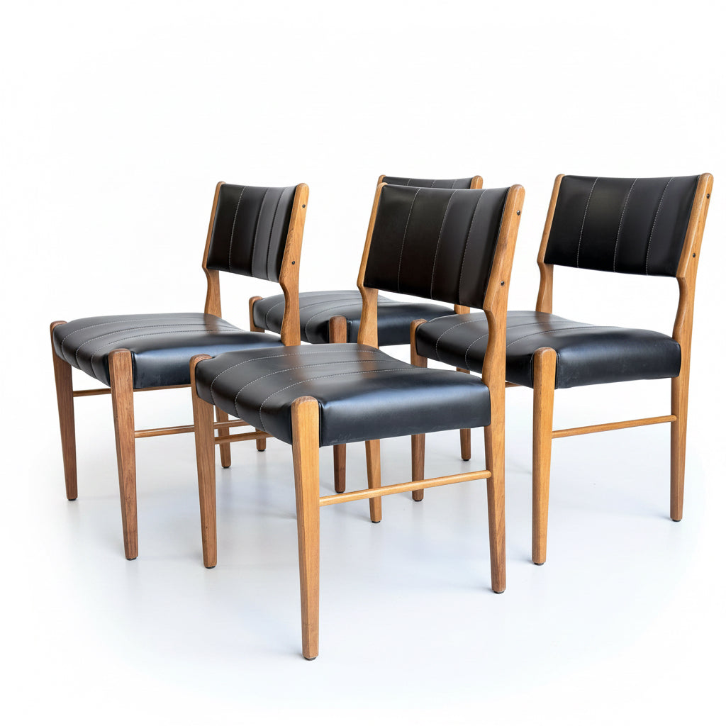 A set of four Vintage TH Brown Blackwood Dining Chairs (Revive) is arranged in two rows on a concrete floor against a plain light-colored wall.