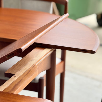 Close-up of a Fully Restored Parker 90 Round Extension Butterfly Table Only (Rediscover), featuring its signature mid-century modern extension mechanism and smooth teak wood grain with a partially inserted leaf.