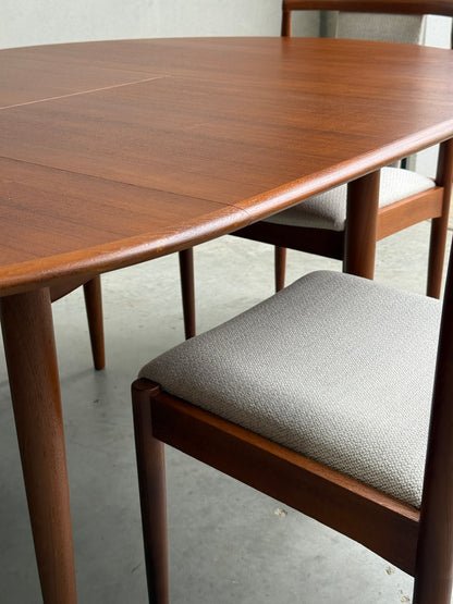A close-up of the Fully Restored Parker 90 Round Extension Butterfly Table Only (Rediscover), showcasing its rounded edges and mid-century modern design on a concrete floor.