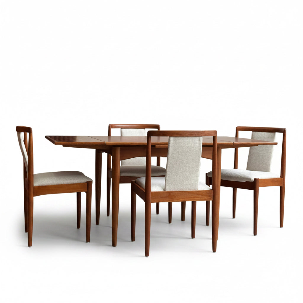 A fully restored Parker Dining Suite 5 Piece Square - Number 140 (Rediscover), featuring a teak table and four matching chairs with light upholstery, set against a minimalist concrete wall background.