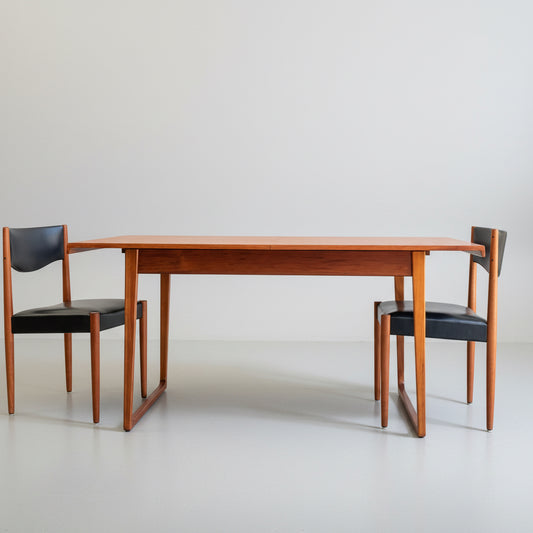 The Rare Gerald Easden Rectangular Extension Dining Table – Fully Professionally Restored is shown with two matching chairs featuring black seats and backrests, all set against a plain white background.