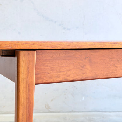 Close-up of the Rare Gerald Easden Rectangular Extension Dining Table (Rediscover), showcasing its clean lines and smooth finish against a plain, light-colored wall background.
