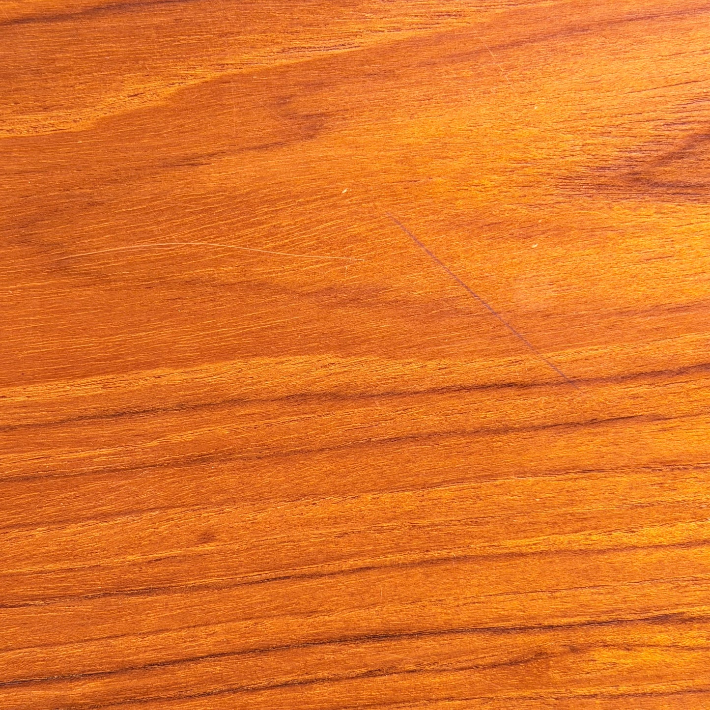 Close-up of a smooth, polished wooden surface with rich natural grain in warm brown and gold hues—echoing Scandinavian-inspired Australian design as seen in the Vintage Parker Dining Suite 5 Piece Square - Number 140 (Refine). Elegant color variation is highlighted.