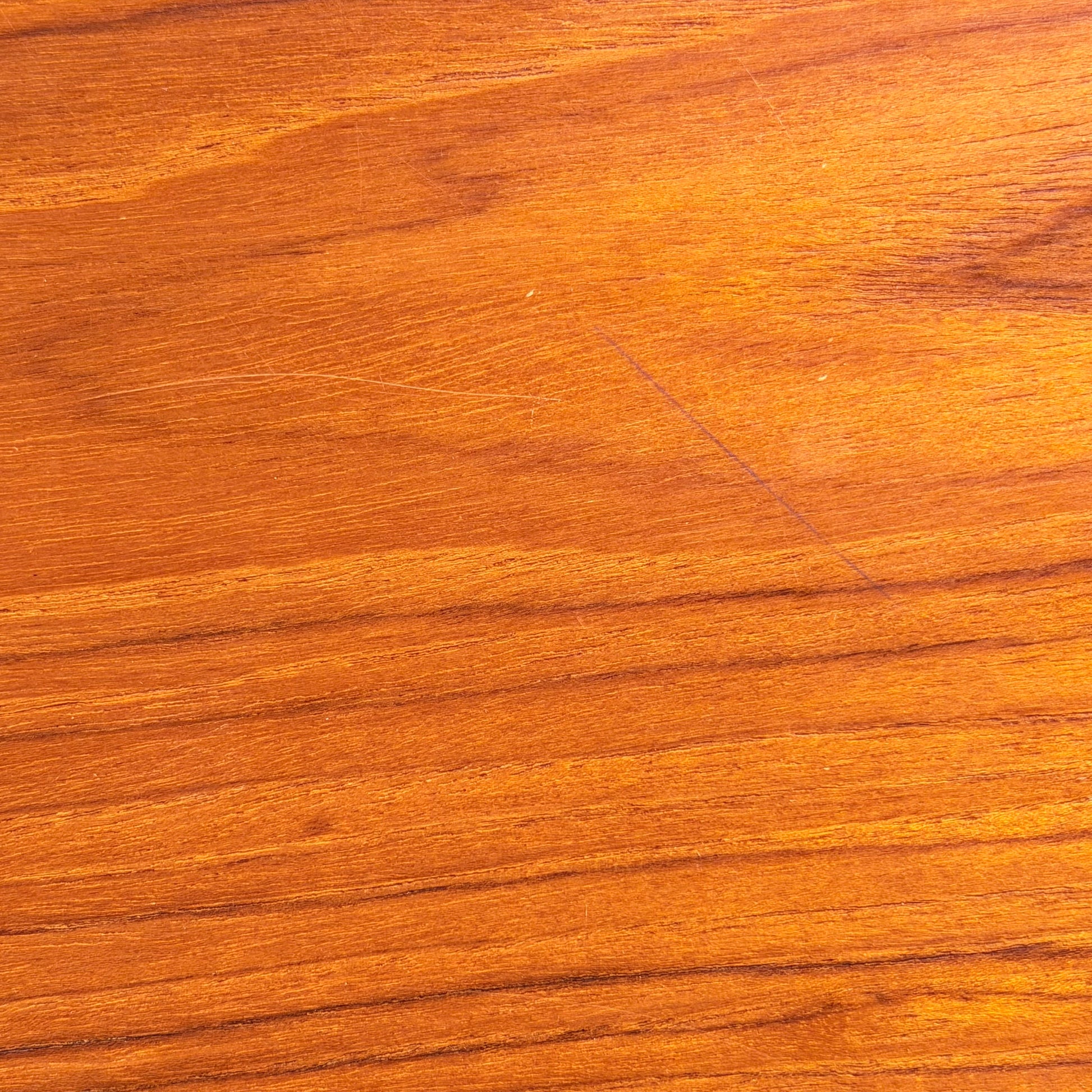 Close-up of a smooth, polished wooden surface with rich natural grain in warm brown and gold hues—echoing Scandinavian-inspired Australian design as seen in the Vintage Parker Dining Suite 5 Piece Square - Number 140 (Refine). Elegant color variation is highlighted.