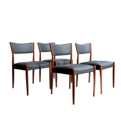Four Parker Number 97 Dining Chairs Set of 4 – Licorice Vinyl are arranged in a row in a bright, minimalist space. 
