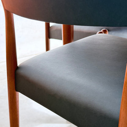 Close-up of a Parker Number 97 Dining Chair from the Set of 4 – Licorice Vinyl (Rediscover), featuring a dark upholstered seat and backrest, wooden legs and frame, and visible seat texture with classic mid-century modern design.