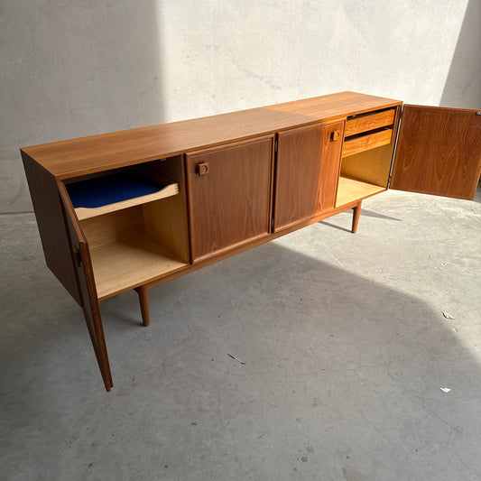 The Iconic Parker Teak 4-Door Sideboard – Restored Mid Century Modern with Tapered Legs is shown with all cabinet doors open, revealing interior shelves and drawers that highlight exceptional Australian craftsmanship.